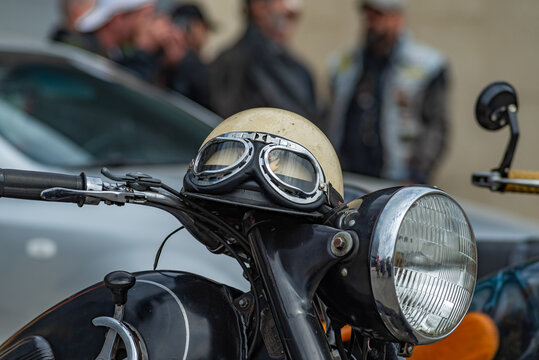 Vintage style motorbike helmet with goggles on the motorcycle handlebar