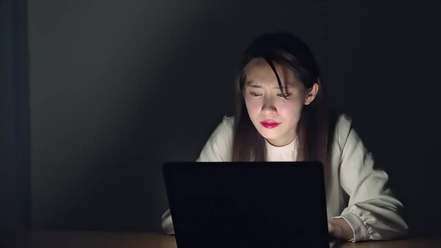 暗い部屋でパソコン作業をする女性　スローモーション