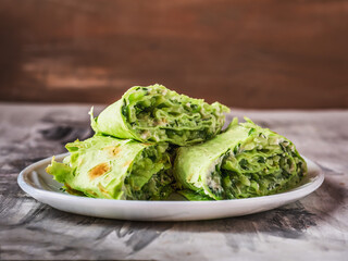 Green rolls with cheese, vegetables and herbs on a plate