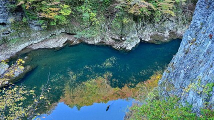 遊歩道から見た紅葉を映す抱返り渓谷の情景＠秋田