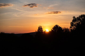 Fototapeta na wymiar The sun sets behind the mountains during spring.