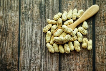 Peanuts on wooden spoon.