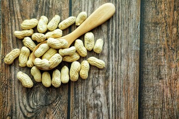 Peanuts on wooden spoon.