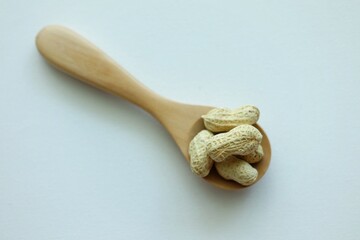 Peanuts on wooden spoon.