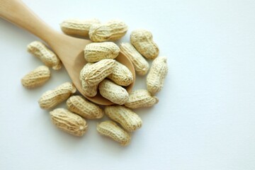 Peanuts on wooden spoon.