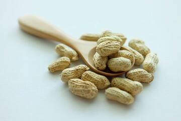 Peanuts on wooden spoon.