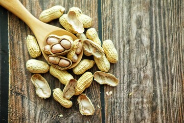 Peanuts on wooden spoon.