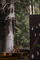 Elements of a sports rope park in the forest.Passing a route with obstacles at a height above the ground.Cables and ropes for hiking are strung between the tree.Outdoor activities for the whole family