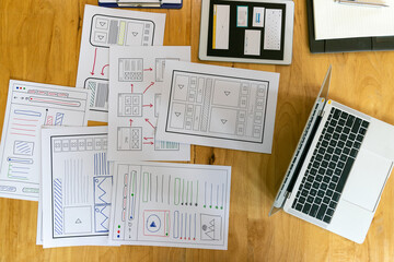 Fototapeta premium Top view of Creative flat lay UX designer working space and office supplies. Smartphone and tablet application layout prototype project.