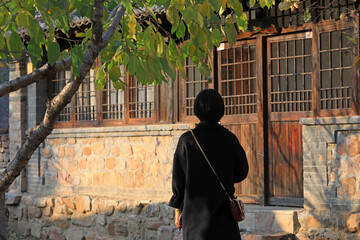 A lady's back is in front of an old house, China,