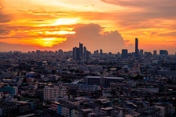Fototapeta premium The high angle background of the city view with the secret light of the evening, blurring of night lights, showing the distribution of condominiums, dense homes in the capital community