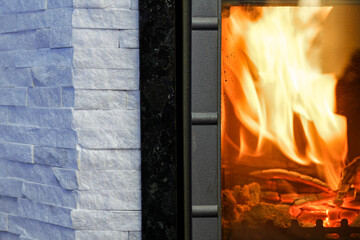 Close up modern fireplace with white brick wall. Comfort and warmth of the home hearth