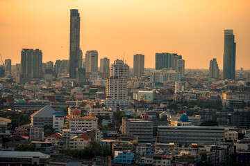Obraz premium The high angle background of the city view with the secret light of the evening, blurring of night lights, showing the distribution of condominiums, dense homes in the capital community
