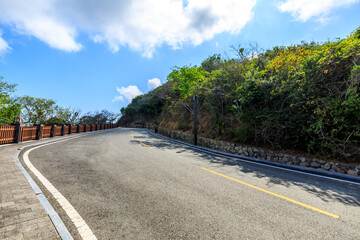 Mountain road landscape under blue sky.