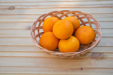 Oranges in a basket on a wooden background