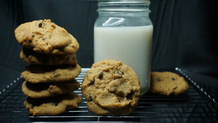 Selective focus of homemade softcookies with milk on behind using black background