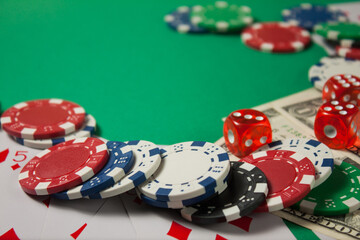 Classic playing cards, chips, red dice and dollars on green background. Gambling and casino concept.