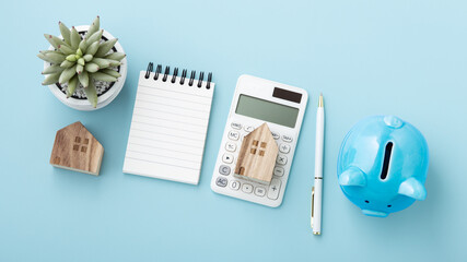 Housing finance concept, calculator with house model and piggy bank