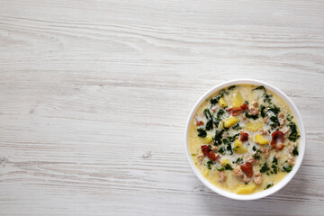 Homemade Zuppa Toscana with Kale and Bread in a white bowl, top view. Flat lay, overhead, from above. Space for text.