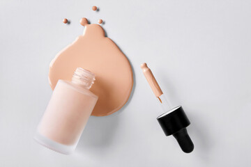 Spilled Liquid foundation. Mockup glass bottle of correction cosmetic product with pipette. Beauty...