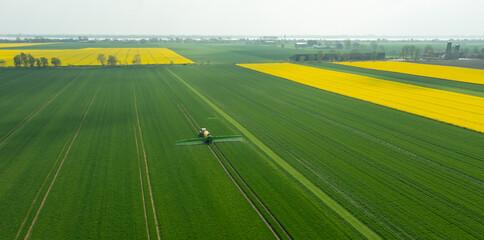 Traktor mit Feldspritze beim Ausbringen von Pflanzenschutzmittel gegen Pestizid © ShDrohnenFly