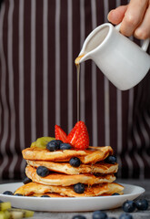 Chef pouring honey on pancakes