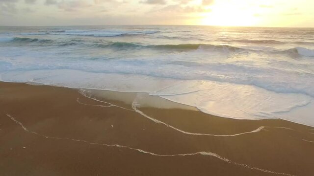 Aerial view of sunsets over the sea. Beautiful waves. Beautiful sea. Summer sunset seascape. Sunsets on the beach of the Atlantic Ocean. Texture of the water. Top view of the fantastic natural sunset.