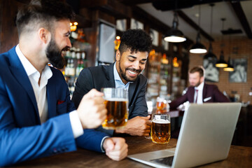 Group of happy friends drinking beer at the pub and having fun