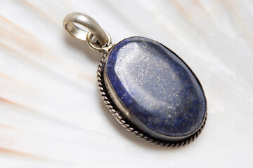 Metal frame mineral stone pendant on white shell background
