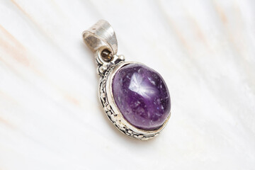 Metal frame mineral stone pendant on white shell background