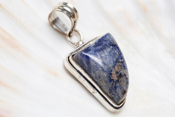 Metal frame mineral stone pendant on white shell background