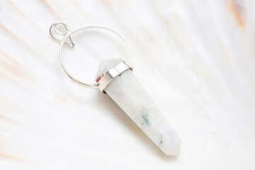 Metal frame mineral stone pendant on white shell background