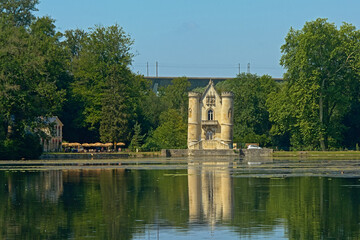 Fototapeta na wymiar Castle of the white queen in neo gothic style, reflecting in the water of Comelles lake in Coye-la-Forêt 