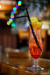 Red non-alcoholic cocktail decorated with a lemon slice on the bar. Close-up, selective focus