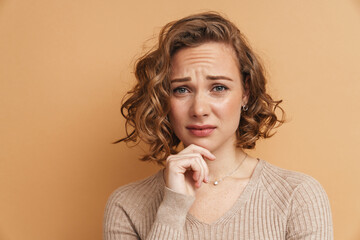 Young ginger puzzled woman frowning and looking at camera