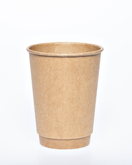 Photo of a disposable brown paper cup on a white background. Photo of a coffee cup made of recyclable materials. Empty paper coffee cup.