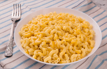 Macaroni and cheese on a white plate on a gray background