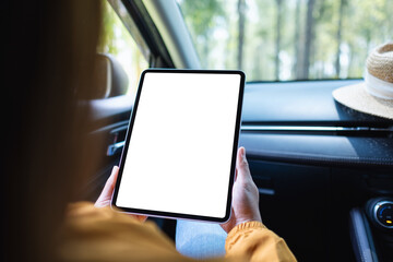Mockup image of a woman holding and using digital tablet with blank screen in the car