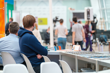 Unrecognizable man siting at conference registration desk