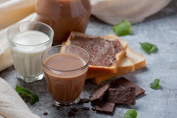 Glass of chocolate milk on the dark background.