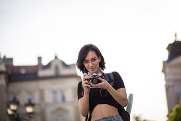  Young woman taking photo in the city with camera.