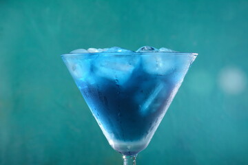 Blue lagoon cocktail with blue curacao liqueur, vodka, lemon juice and soda, decorated with lemon slice and mint leaves. - obrazy, fototapety, plakaty