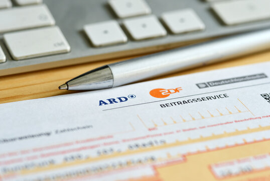 Leipzig, Germany, May-17-2021 Close up of bank transfer form for german radio and tv broadcast service with pen and keyboard (gez beitragsservice)