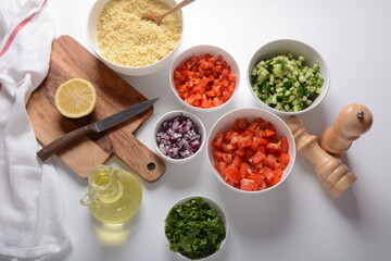 White bowls with grated vegetables of different colors. Cooking board with Ingredients ready for the salad.