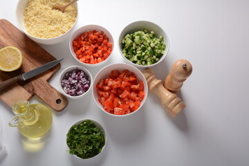 White bowls with grated vegetables of different colors. Cooking board with Ingredients ready for the salad.