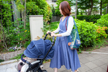 ベビーカーを押して散歩をする、妊娠中のお母さん