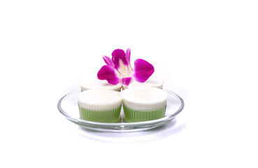 Pandan coconut milk jelly served on a plate with orchids isolated on white background