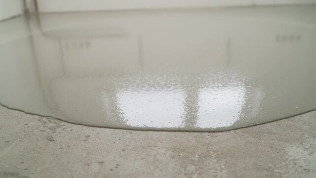 Leveling with a mixture of cement floors. Worker Apply Self Leveling Floor. Self-leveling floor. Self-leveling epoxy.