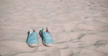 Naklejka premium beach shoes. sand background on the beach. summer vacation beach background.