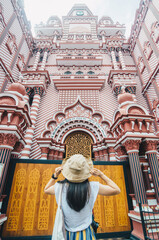 Tourist woman standing in front of Jami Ul-Alfar Mosque or the Red Mosque an iconic and most popular historic mosque in Colombo, Sri Lanka.